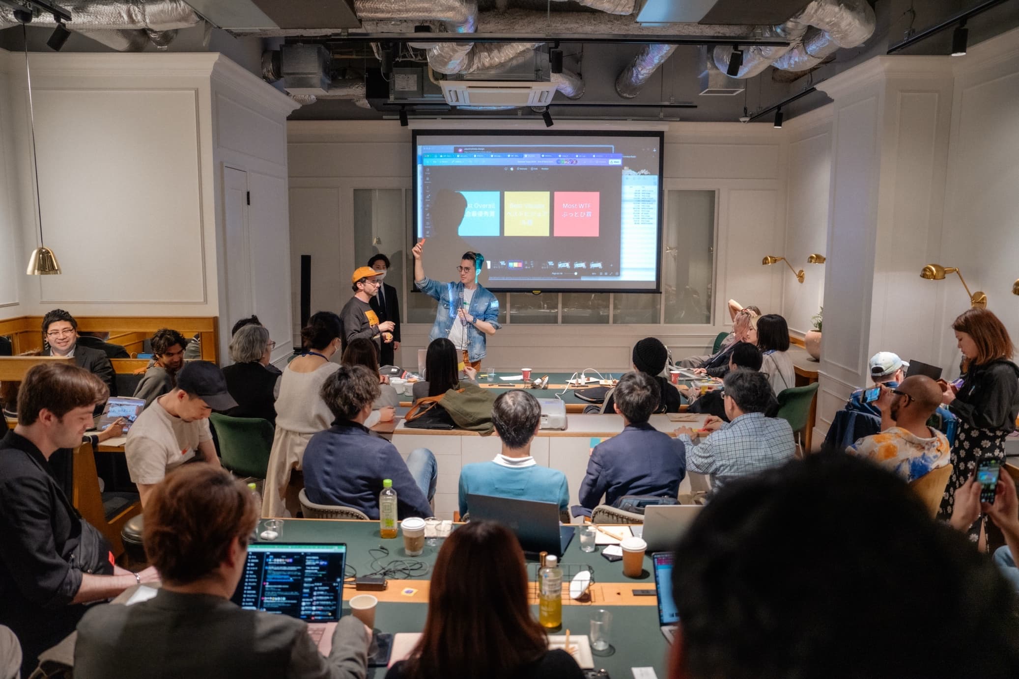 Workshop with creators at tables and presenters teaching