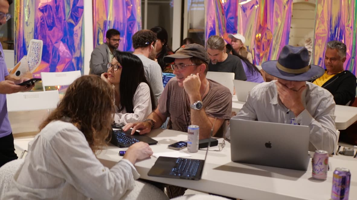 Creators collaborating at laptops during a GenJam